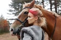 Woman on a horse in the fall. Creative bright pink makeup on the girl face, hair coloring. Portrait of a girl with a horse. Horseb