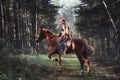 Woman on a horse in the fall. Creative bright pink makeup on the girl face, hair coloring. Portrait of a girl with a horse. Horseb