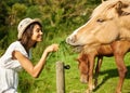 Woman, horse and outdoor for feeding grass with smile, care or love for pet at farm, countryside or spring. Girl, equine Royalty Free Stock Photo