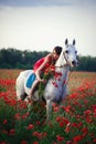 Woman with a horse in a poppy field