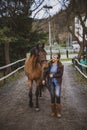 Woman with horse walking to the stable