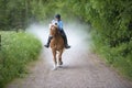 Woman horseback riding on country road Royalty Free Stock Photo