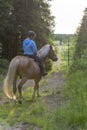 Woman horseback riding in forest path Royalty Free Stock Photo