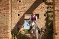 Woman horsewoman, young and beautiful, standing, riding her horse, in the field next to a ruined building. Concept horse riding,