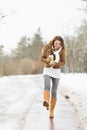 Woman with hot beverage walking in winter park Royalty Free Stock Photo
