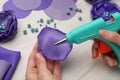 Woman with hot glue gun making craft at wooden table, closeup Royalty Free Stock Photo