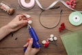 Woman with hot glue gun making craft at wooden table, top view Royalty Free Stock Photo