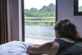 A woman on a hotel lying on a crawati looking at the resort. Girl looking at river over balcony