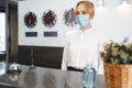 Woman hotel receptionist wearing medical mask to protect from coronavirus infection