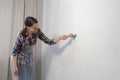 Woman house painter is painting wall using brush doing renovation at home. Royalty Free Stock Photo