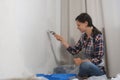 Woman house painter is painting wall using brush doing renovation at home. Royalty Free Stock Photo