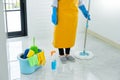 Woman housekeeper with mop and bucket with cleaning agents for cleaning floor at home, Floor care and cleaning services