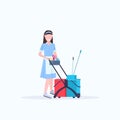 Woman housemaid holding trolley cart with supplies female cleaner janitor in uniform cleaning service concept flat full