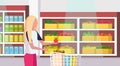 Woman housewife carrying full trolley cart of food purchases big grocery shop supermarket interior female customer super