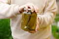 Woman housewife hand holding glass jar of pickled cucumbers. Domestic preparation pickling and canning of vegetables Royalty Free Stock Photo