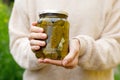 Woman housewife hand holding glass jar of pickled cucumbers. Domestic preparation pickling and canning of vegetables Royalty Free Stock Photo