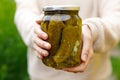 Woman housewife hand holding glass jar of pickled cucumbers. Domestic preparation pickling and canning of vegetables Royalty Free Stock Photo