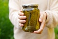 Woman housewife hand holding glass jar of pickled cucumbers. Domestic preparation pickling and canning of vegetables Royalty Free Stock Photo