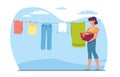 Woman housewife hangs washed laundry on clothesline. Clothing hanging on rope. Underwear and garments attached with