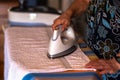 The woman the housewife irons clothes at home. On the Ironing Board iron and towel, as well as other things of different colors. Royalty Free Stock Photo