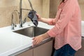 Woman housewife wiping kitchen faucet over sink with rag Royalty Free Stock Photo