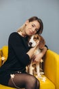 Woman hug puppy of beagle on yellow chair