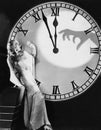 Woman with huge clock recoiling from frightening hand