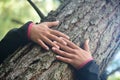 Woman hugging a big tree in a park. Royalty Free Stock Photo