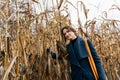 Woman hugging dry corn stalks in cornfield in autumn Royalty Free Stock Photo