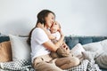 Woman hugging and kissing her little son sitting on a couch