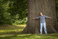 Woman hugging a old big tree in the summer forest, with love nature Royalty Free Stock Photo