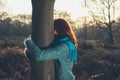 Woman hugging tree at sunset Royalty Free Stock Photo