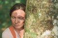 Woman is hugging tree trunk in forest Royalty Free Stock Photo