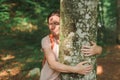 Woman is hugging tree trunk in forest Royalty Free Stock Photo