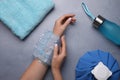Woman with ice pack at grey table, top view. Heat stroke treatment