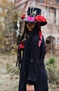 A woman in the image of Baron Saturday poses against the backdrop of an old ruined brick building. The model is dressed Royalty Free Stock Photo