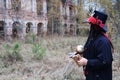 A woman in the image of Baron Saturday poses against the backdrop of an old ruined brick building. The model stands with Royalty Free Stock Photo