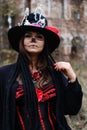 A woman in the image of Baron Saturday poses against the backdrop of an old ruined brick building. The model is wearing Royalty Free Stock Photo