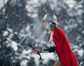 Woman in image of Germanic-Scandinavian God of thunder and storm goes with hammer in her hand. Cosplay. Royalty Free Stock Photo