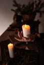 A woman dressed in a medieval dress holds a burning white candle in her hand. Mystery witch Royalty Free Stock Photo