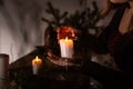 A woman dressed in a medieval dress holds a burning white candle in her hand. Mystery witch Royalty Free Stock Photo