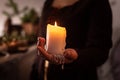 A woman dressed in a medieval dress holds a burning white candle in her hand. Mystery witch Royalty Free Stock Photo