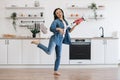 Woman imitating guitar player with cordless vacuum at home