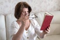 Woman with impaired vision reading a book through two glasses Royalty Free Stock Photo