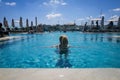 Woman in the infinity swimming pool at Aqualuna Beach Club, Valletta, Malta.