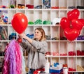 a woman inflates of helium from a red balloon.