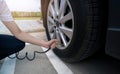 Woman inflates the tire. Woman checking tire pressure and pumping air into the tire of car wheel. Car maintenance service for Royalty Free Stock Photo