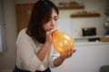 Woman inflating a balloon