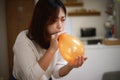 Woman inflating a balloon