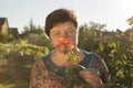 Middle-aged woman and a rose. The woman inhales the aroma of the rose at sunset. The rose shines at sunset